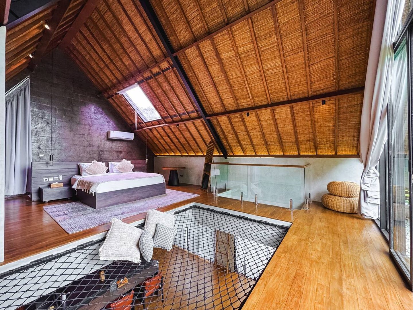Mezzanine bedroom beneath the woven bamboo A-frame, suspended net alongside